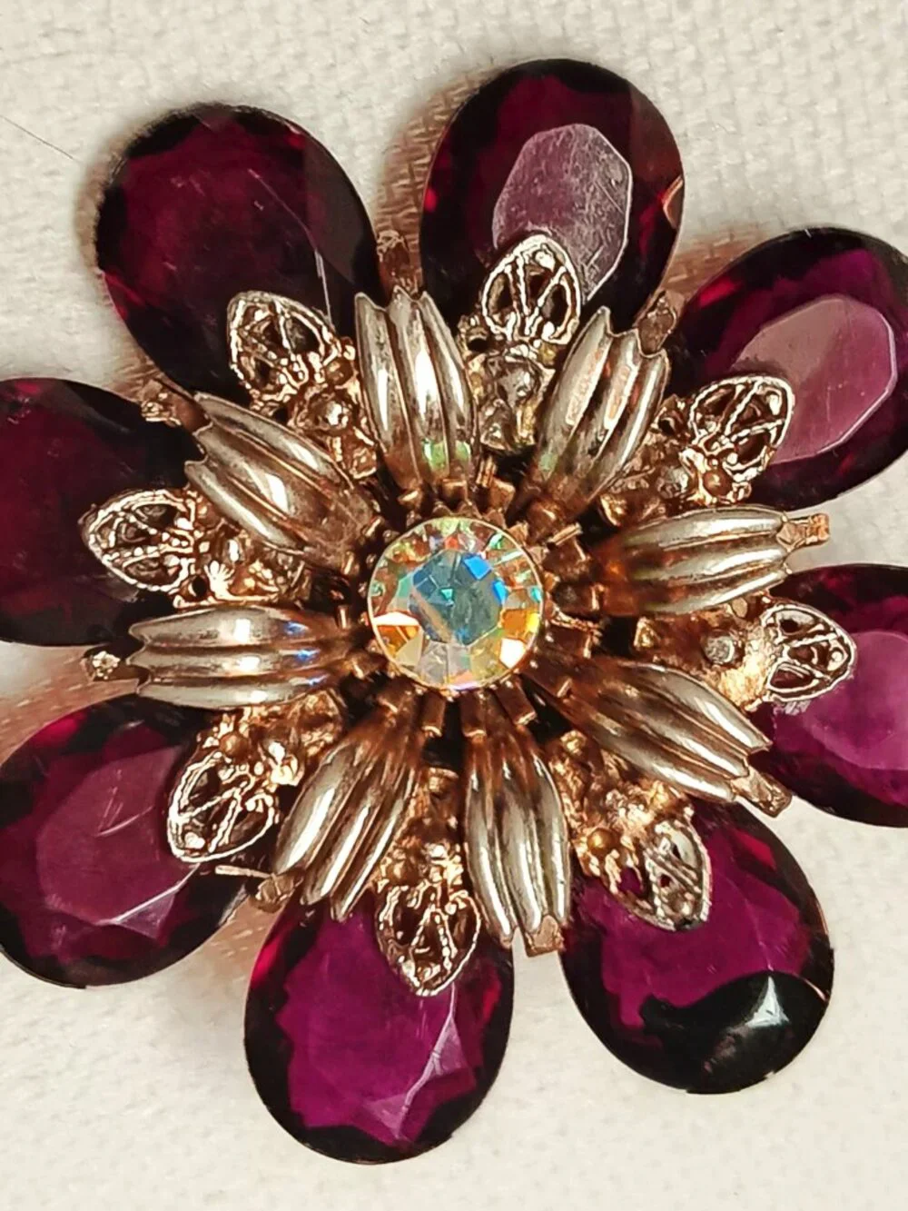 Vintage ruby lucite brooch with aurora borealis central rhinestone.